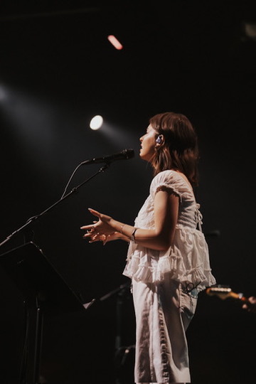 Profile of a worship singer under a single spotlight