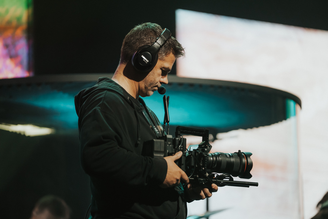 Videographer focused behind a cinema camera at a live event