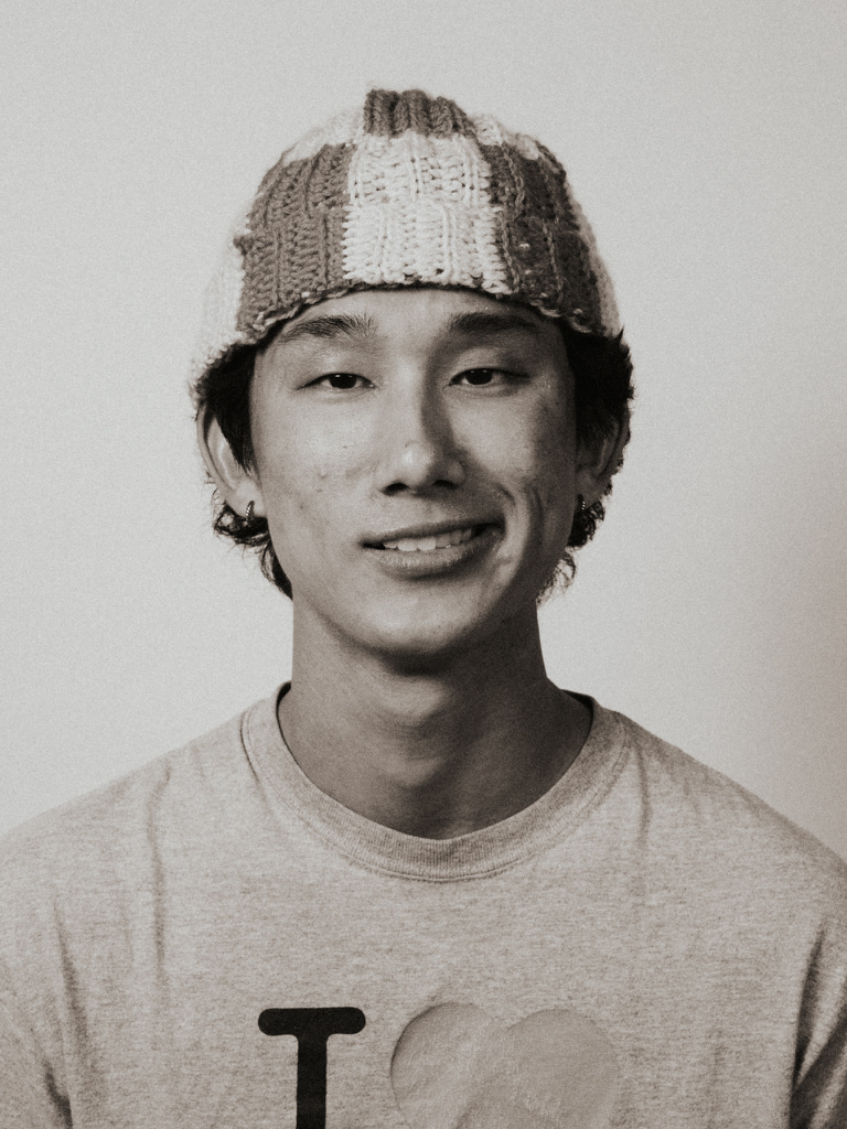 Sepia studio portrait smiling in a checkered knit beanie