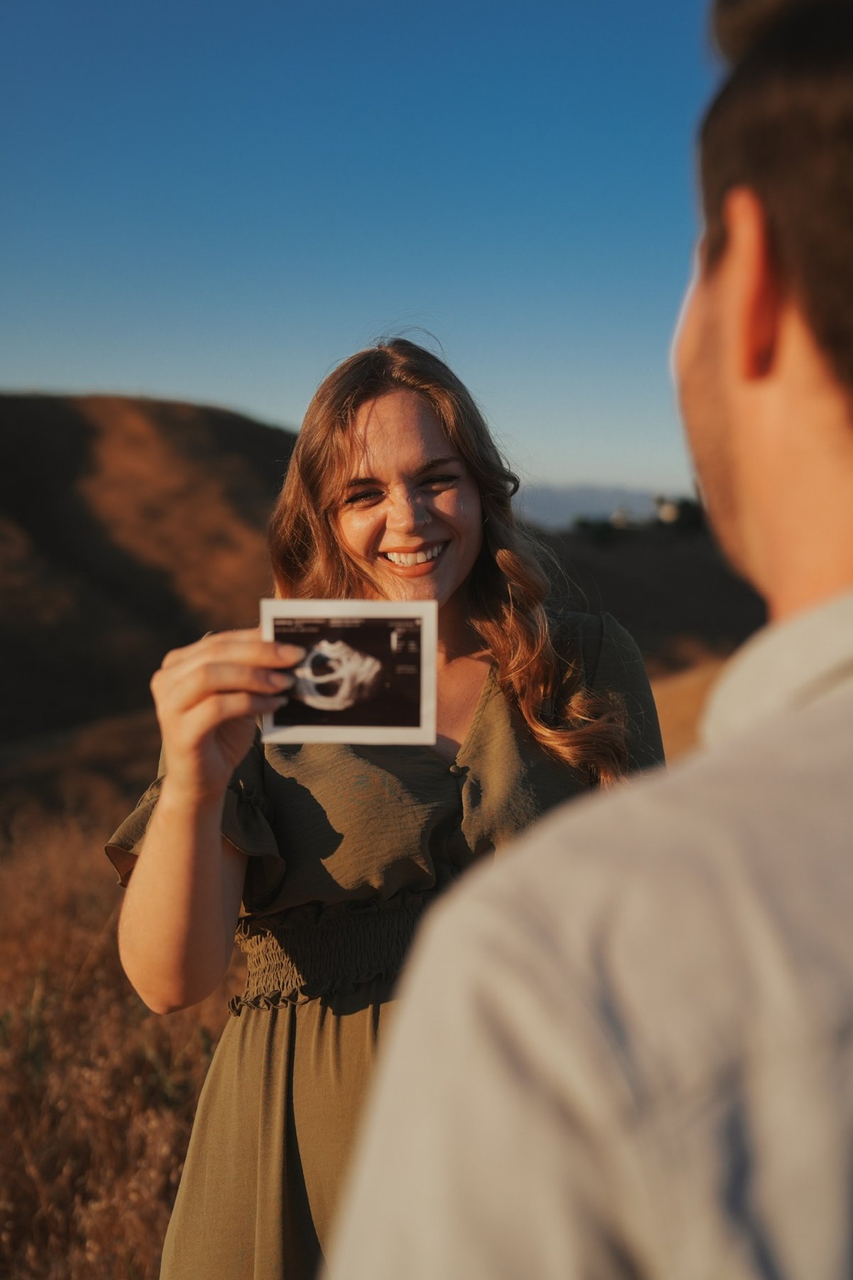 Expecting mother joyfully showing an ultrasound photo
