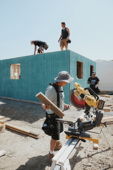 Volunteers building a home on a sunny work site