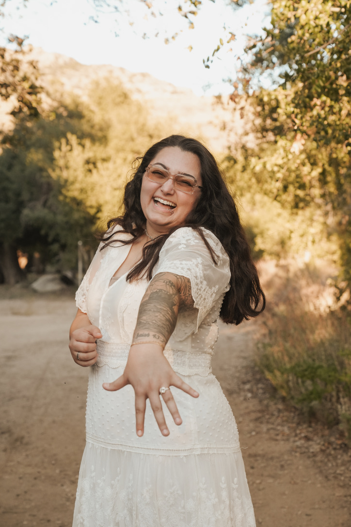Bride-to-be laughing while showing off her engagement ring
