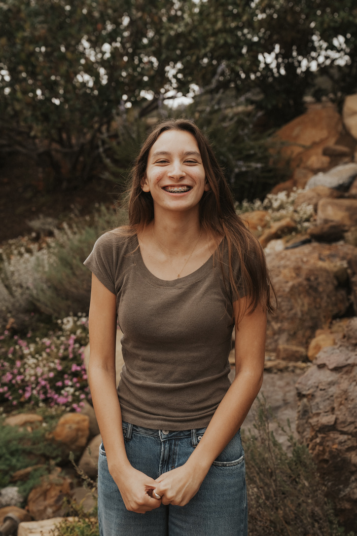 Young woman laughing among rocks and garden flowers
