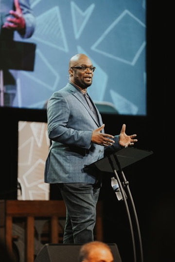 Preacher speaking passionately on stage at a podium