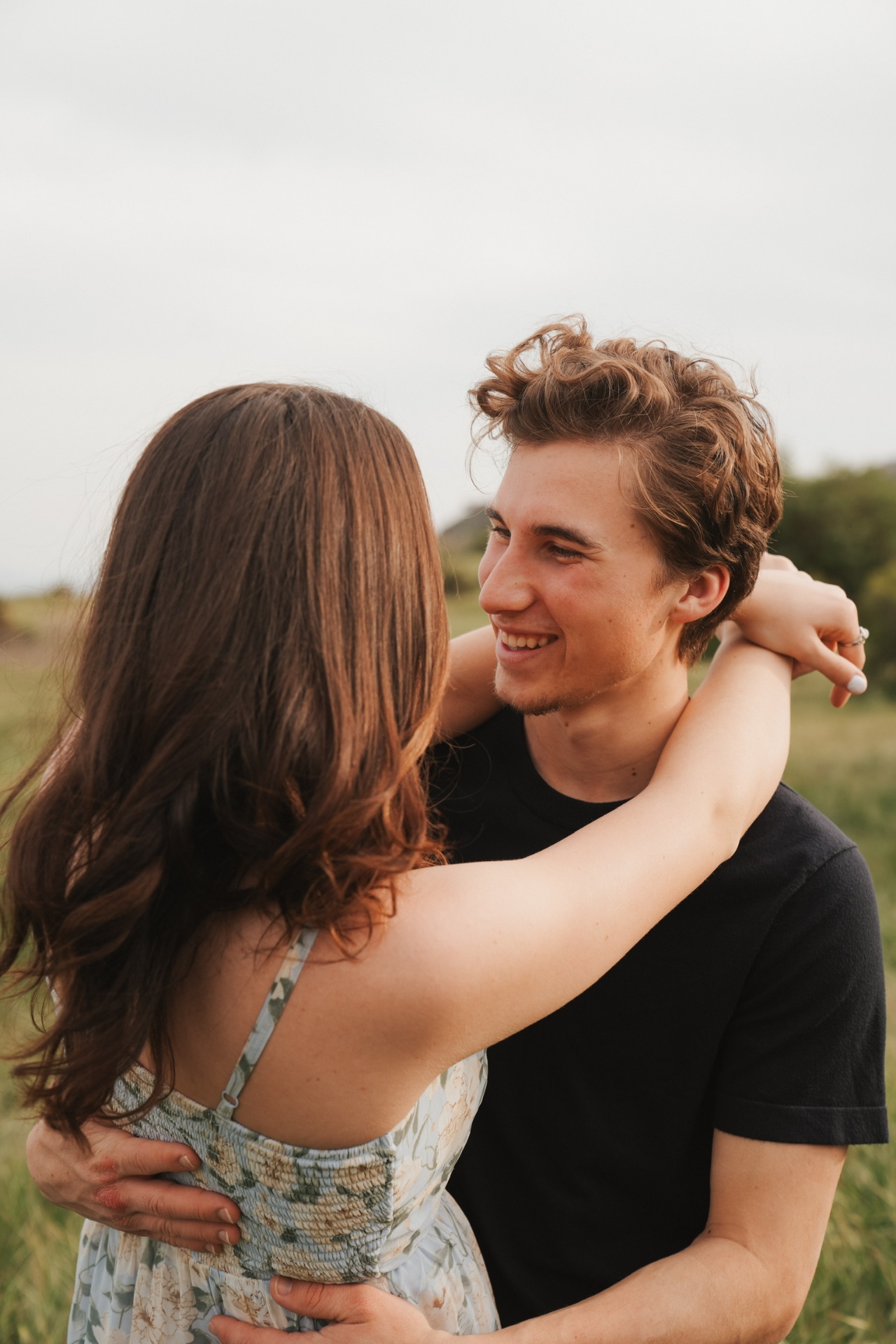 Laughing together with arms wrapped around his neck in the field