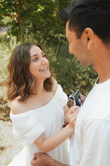 Couple sharing a joyful surprise reveal in the sunshine
