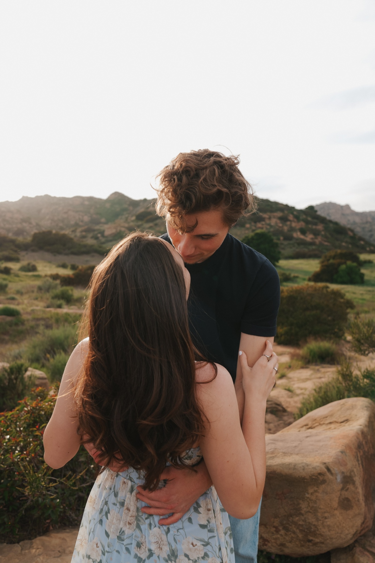 Tender forehead kiss with canyon hills glowing behind