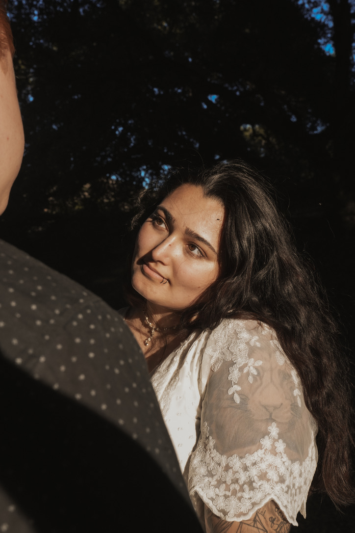 Woman in lace looking lovingly at her partner beneath the trees