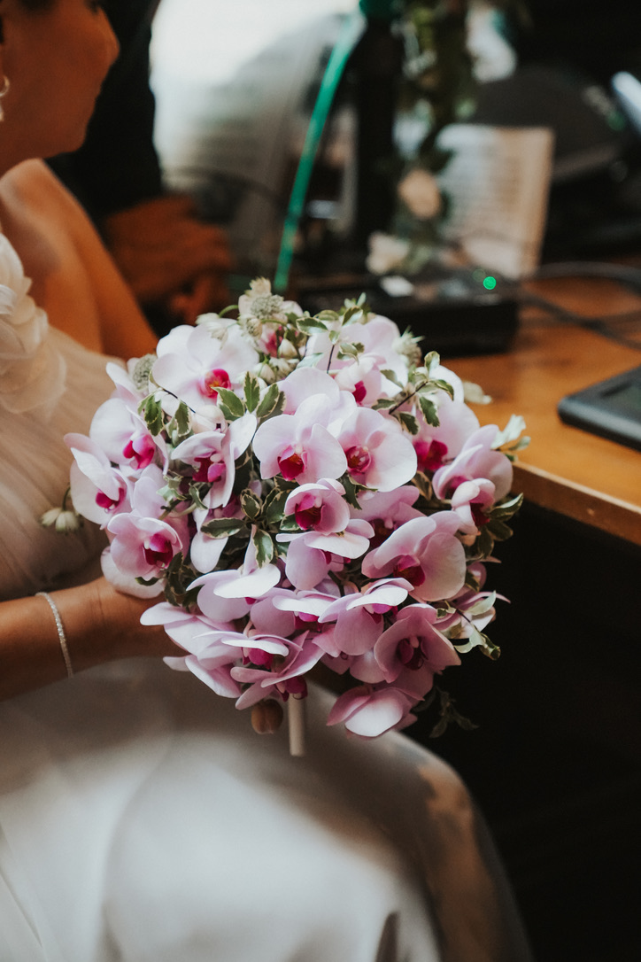 Bride holding a bouquet of pink orchids