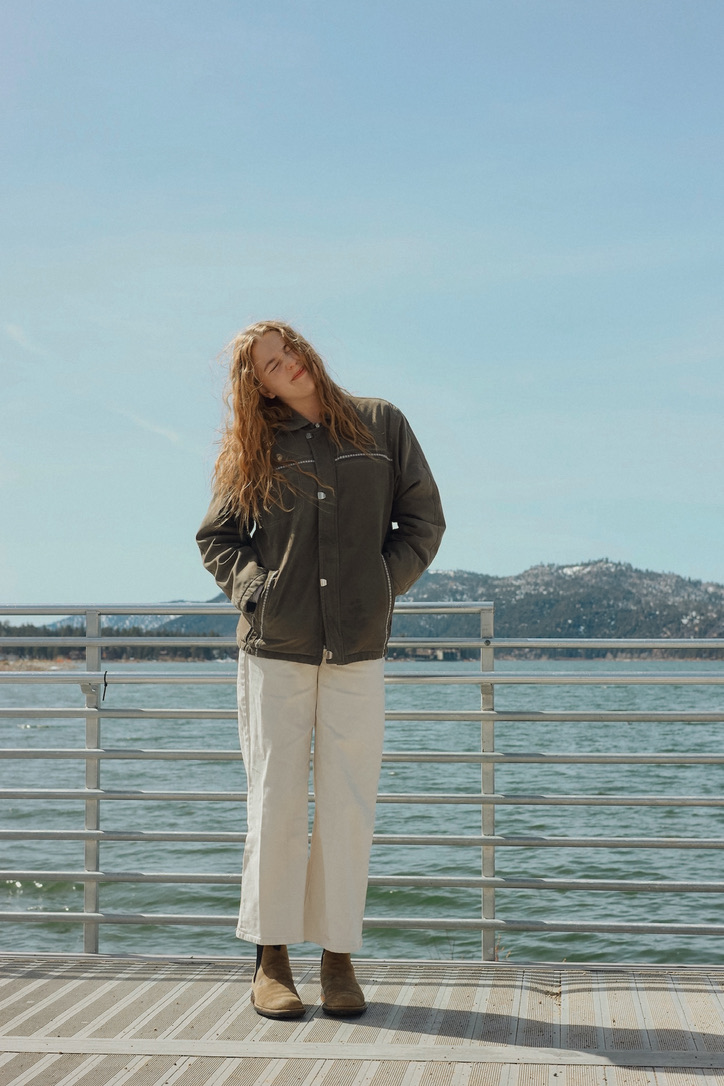 Portrait on a lakeside pier with snowy mountains behind