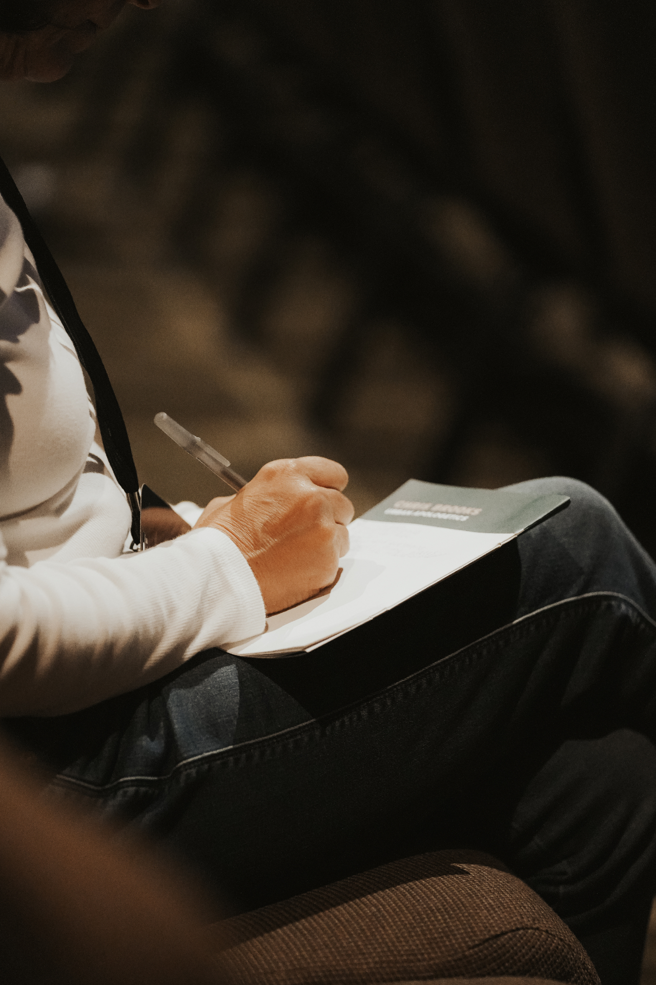 Close-up of hands taking notes on a conference booklet