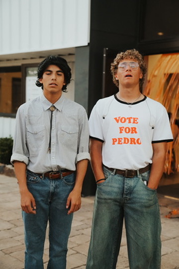 Two friends in retro outfits standing side by side downtown