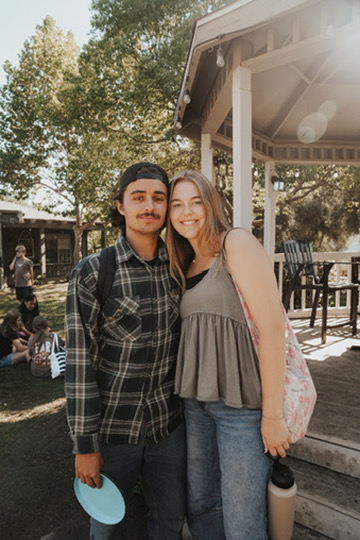 Couple smiling by a gazebo at a summer gathering